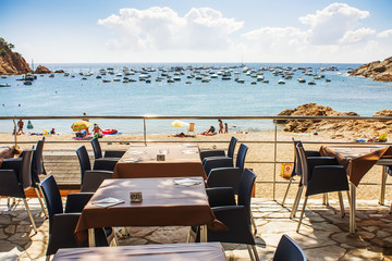 Tables at beach restaurant in Tamariu, Costa Brava, Spain