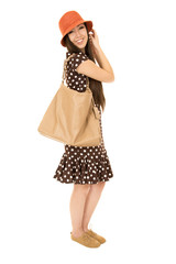 Cute teen model standing wearing polka dot dress smiling at came