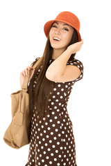 Confident teen girl model wearing a polka dot dress orange hat w