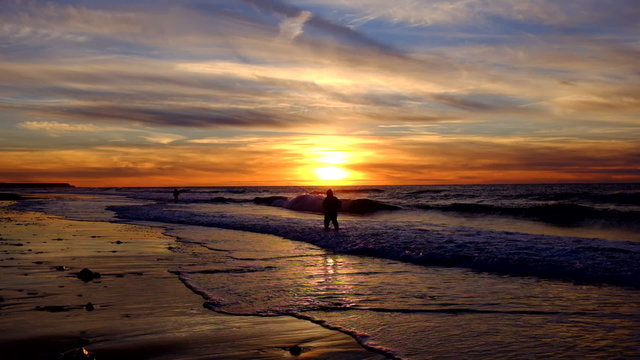 Fishermen at the beach fishing at sunset