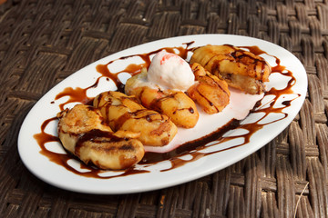 Banana desert with ice cream in seaside cafe
