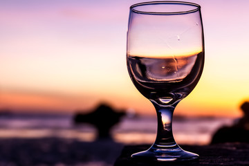 tropical sunset on beach reflected in a wine glass, summertime v