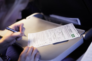 Woman Filling Document in the Airplane