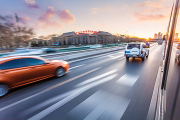 Fototapeta premium Car driving on freeway at sunset, motion blur