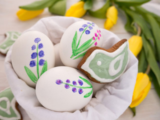 Fototapeta na wymiar Painted Easter eggs and bird shaped cookies