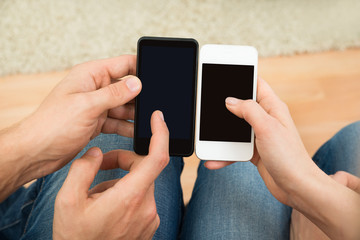 Two People Holding Mobile Phones
