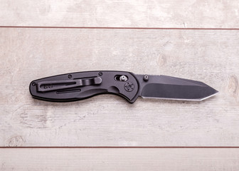 Folding knife on a wooden background