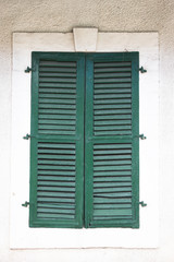 Old green window with closed shutters