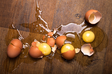 Broken eggs on the wooden floor - 80120989