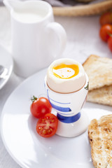 Soft-boiled egg in the morning with toast. In the background of
