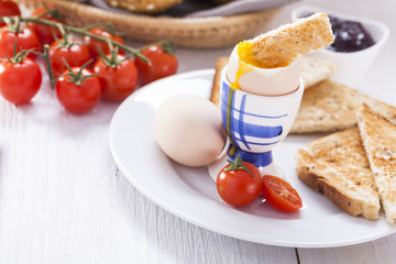 Soft-boiled egg in the morning with toast. In the background of