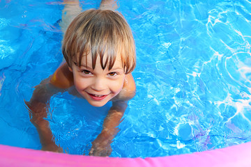 Fototapeta na wymiar Kid swims in the pool.