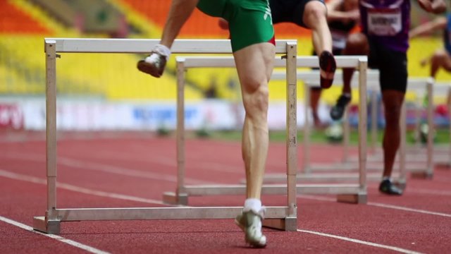 Runners overcome obstacle during race on athletic competition