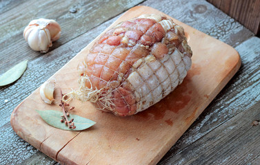 Raw chicken roll ready to roast on a cutting board