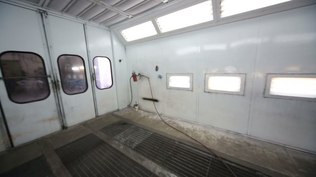 Inside empty paint-spraying booth with metal walls for cars