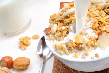 Milk falling on a bowl full of cereal
