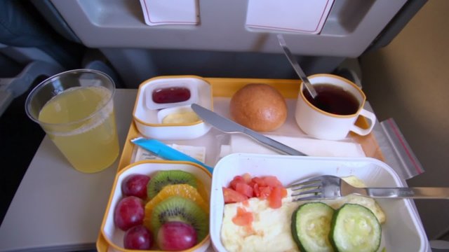 Different meals of breakfast is on small table at plane