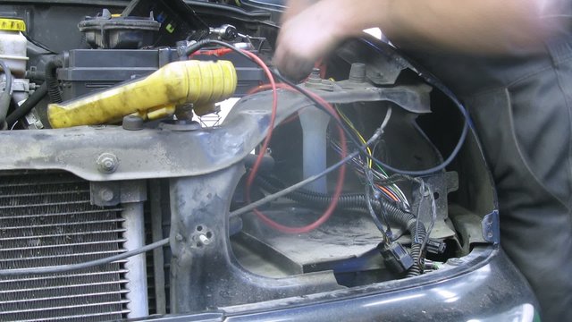 Mechanic working at car with battery on close frontal view
