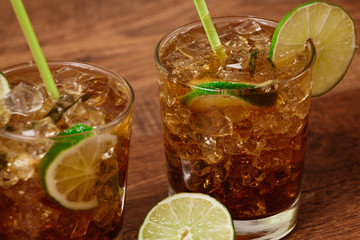 drink concept - cocktail with cola ice cubes and lime