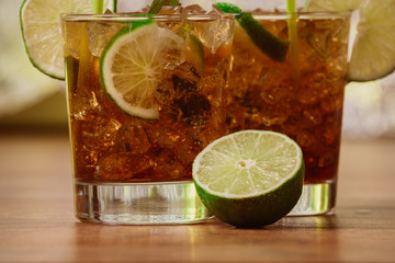 drink concept - cocktail with cola ice cubes and lime