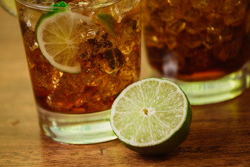 drink concept - cocktail with cola ice cubes and lime