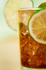 drink concept - cocktail with cola ice cubes and lime