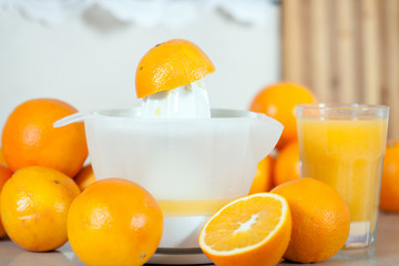  few oranges near the hand juicer on   table.