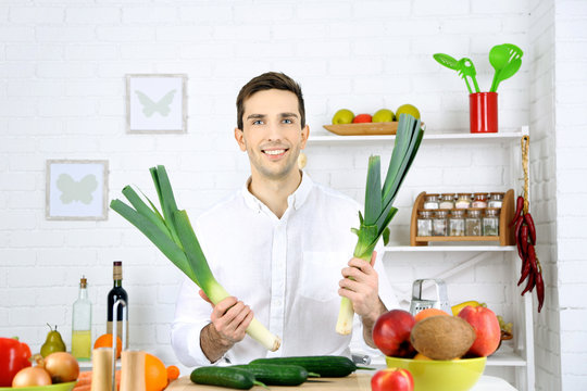 Man at table with different products in kitchen