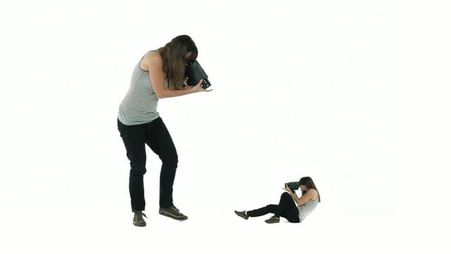 Woman films a smaller version of herself, who in turn lays back to film her larger twin.  Self-reflection, introspection, narcissism and self-analysis.
