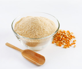 Glass bowl with flour and corn grains isolated on white