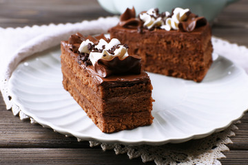 Tasty pieces of chocolate cake on wooden table background