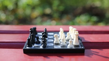 Boy and girl hands move chess piece above chessboard