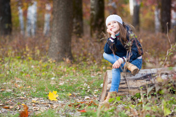 Fototapeta na wymiar girl sitting on a log in the woods