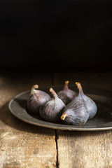Fresh figs in moody natural lighting set with vintage retro styl