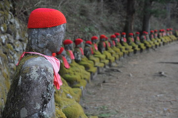 Row of Japanese Buddha wearing red scarf, Jizo statues
