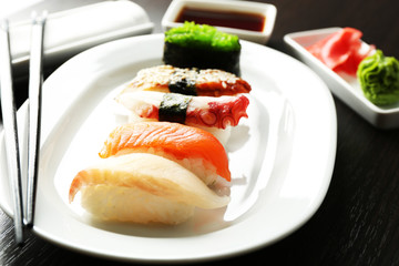 Sushi on plate on wooden table background