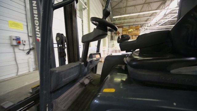 Cabin of loader in warehouse with goods at Caparol factory