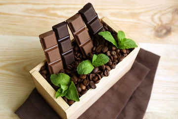 Still life with set of chocolate in wooden box of coffee grains