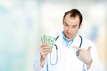 Greedy health care professional male doctor holding money dollar
