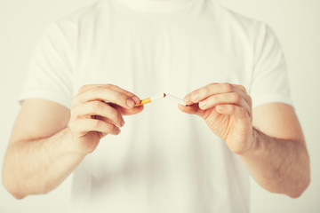 man breaking the cigarette with hands