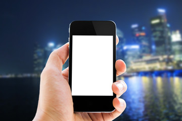 close up hand holding phone on blurred cityscape background