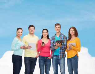 group of teenagers with smartphones and tablet pc