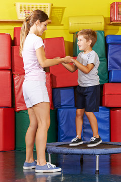Kind hüpft auf Trampolin in Turnhalle