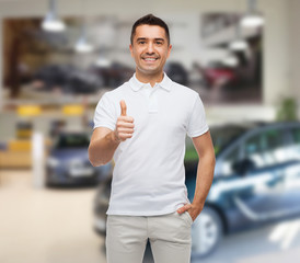 man showing thumbs up over auto show background