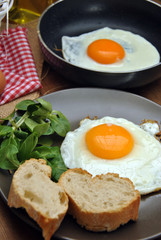 Fried eggs with plate, bread, and oilcan