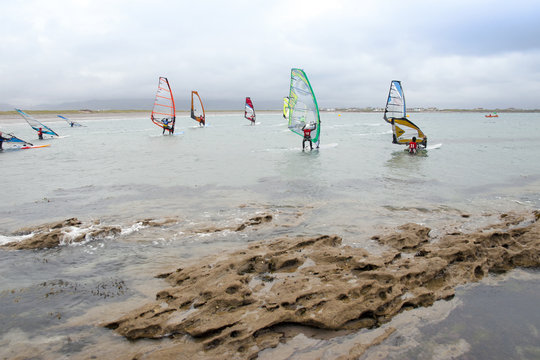 wind surfers braving the strong storm and rocks