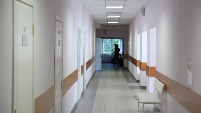 policlinic corridor with silhouette of mother with child on hands in end