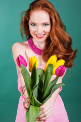 Beautiful redheaded girl is holding tulips