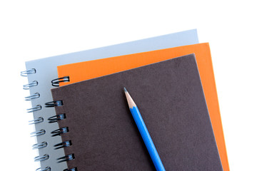 Stack of notebooks (or copybooks) with a pencil 