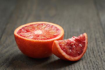 half and section of red orange on wooden table